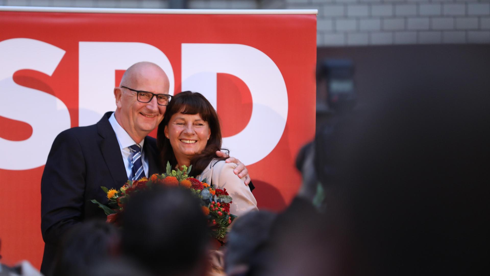 SPD-Wahlparty zur Landtagswahl in Brandenburg: Brandenburgs Ministerpräsident Dietmar Woidke hält eine Rede vor seinen Anhängern, neben ihm seine Ehefrau.