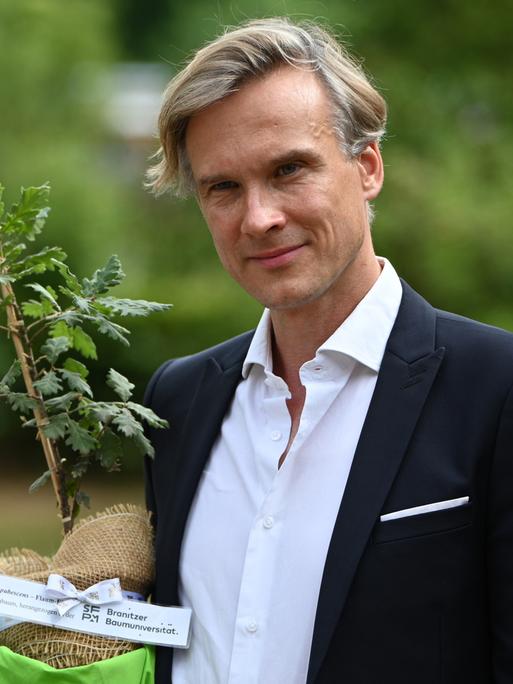 Stefan Körner, Vorstand der Stiftung Fürst-Pückler-Museum Park und Schloss Branitz, hält im Juni 2025 einen Setzling. Mithilfe eines Förderprogramms von EU und brandenburgischem Kulturministerium sollen klimabedingte Schäden erfasst und reduziert werden. Stefan Körner, Vorstand der Stiftung Fürst-Pückler-Museum Park und Schloss Branitz, hält im Juni 2025 einen Setzling. Mithilfe eines Förderprogramms von EU und brandenburgischem Kulturministerium sollen klimabedingte Schäden erfasst und reduziert werden.