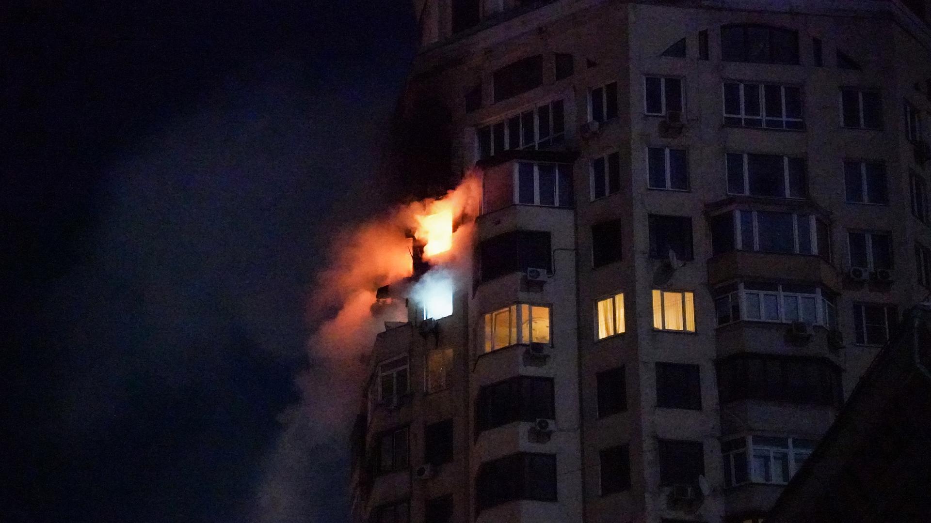 Aus den Fenstern zweier Wohnungen in einem mehrstöckigen Haus in Kiew schlagen die Flammen aus dem Fenster.