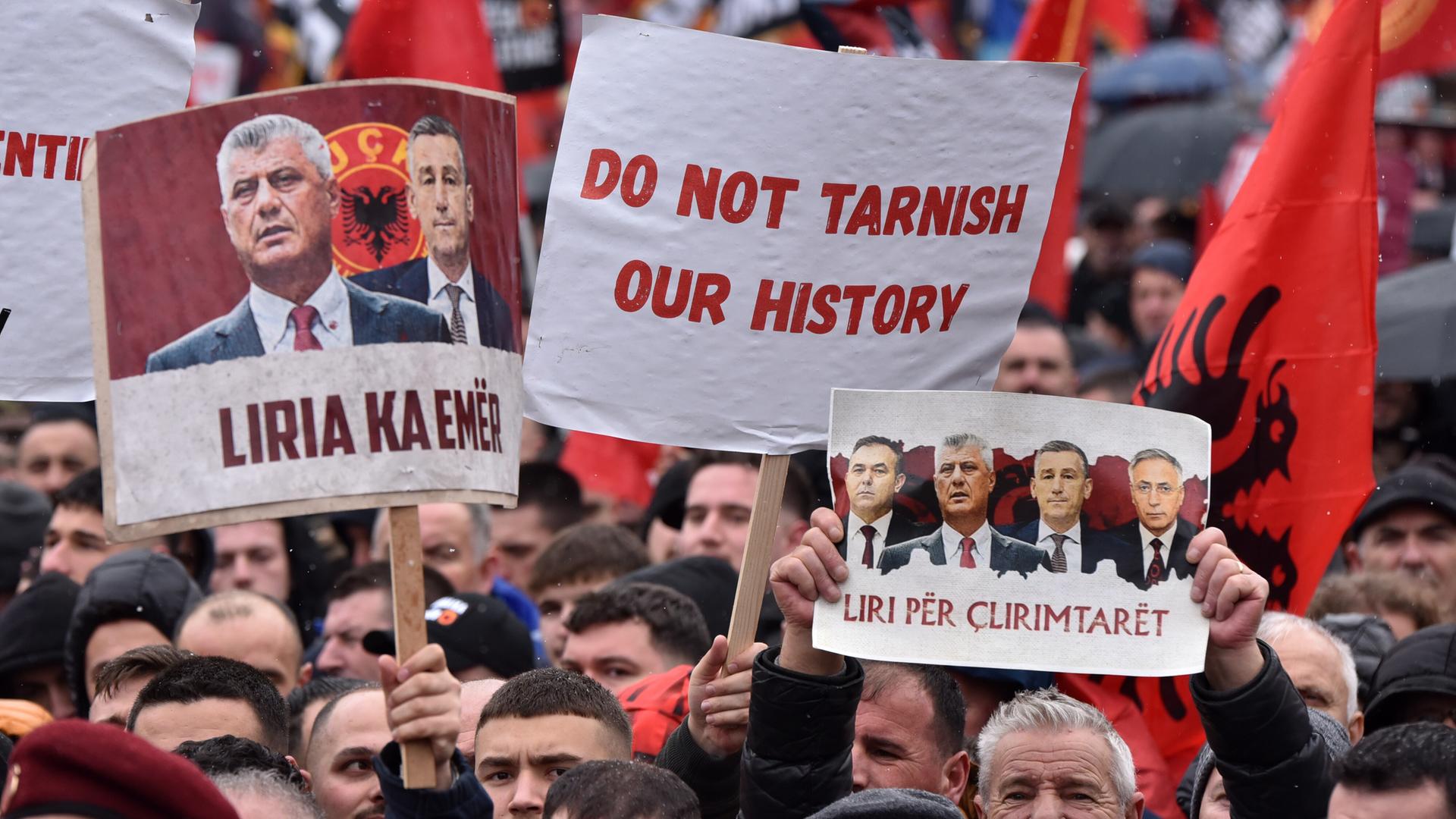 Tausende Menschen nehmen an einer Großdemonstration teil. Auf Schildern sind unter anderem die Angeklagten abgebildet. Auf einem Schild steht: "Do not tarnish our history"!
