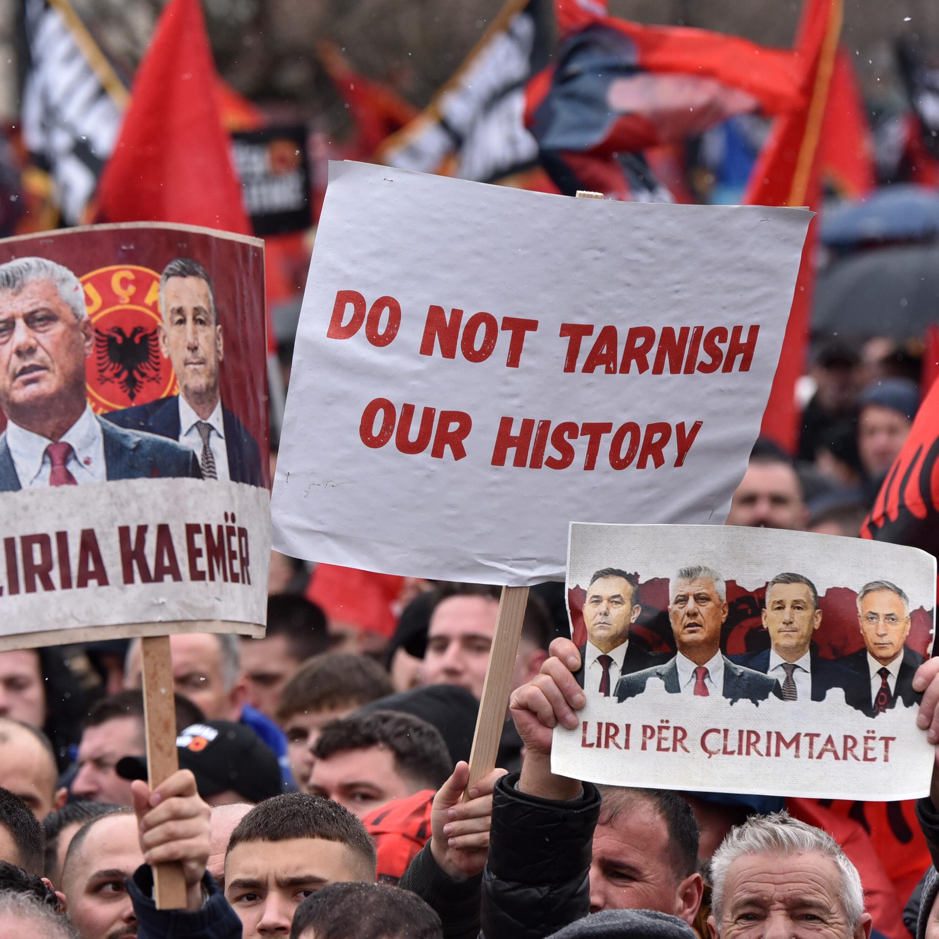 Tausende Menschen nehmen an einer Großdemonstration teil. Auf Schildern sind unter anderem die Angeklagten abgebildet. Auf einem Schild steht: "Do not tarnish our history"!