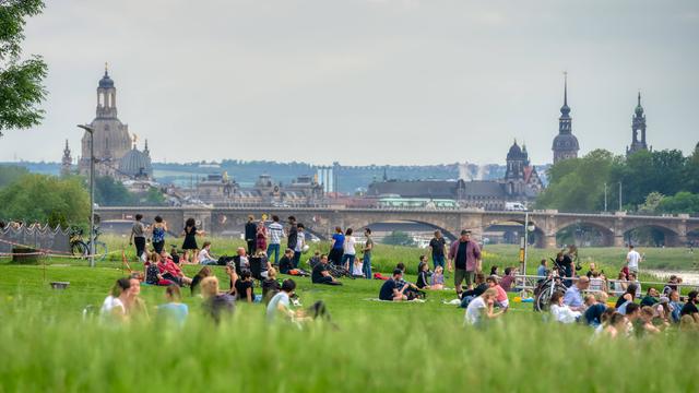 Menschen auf den Elbwiesen mit Blick auf Dresden