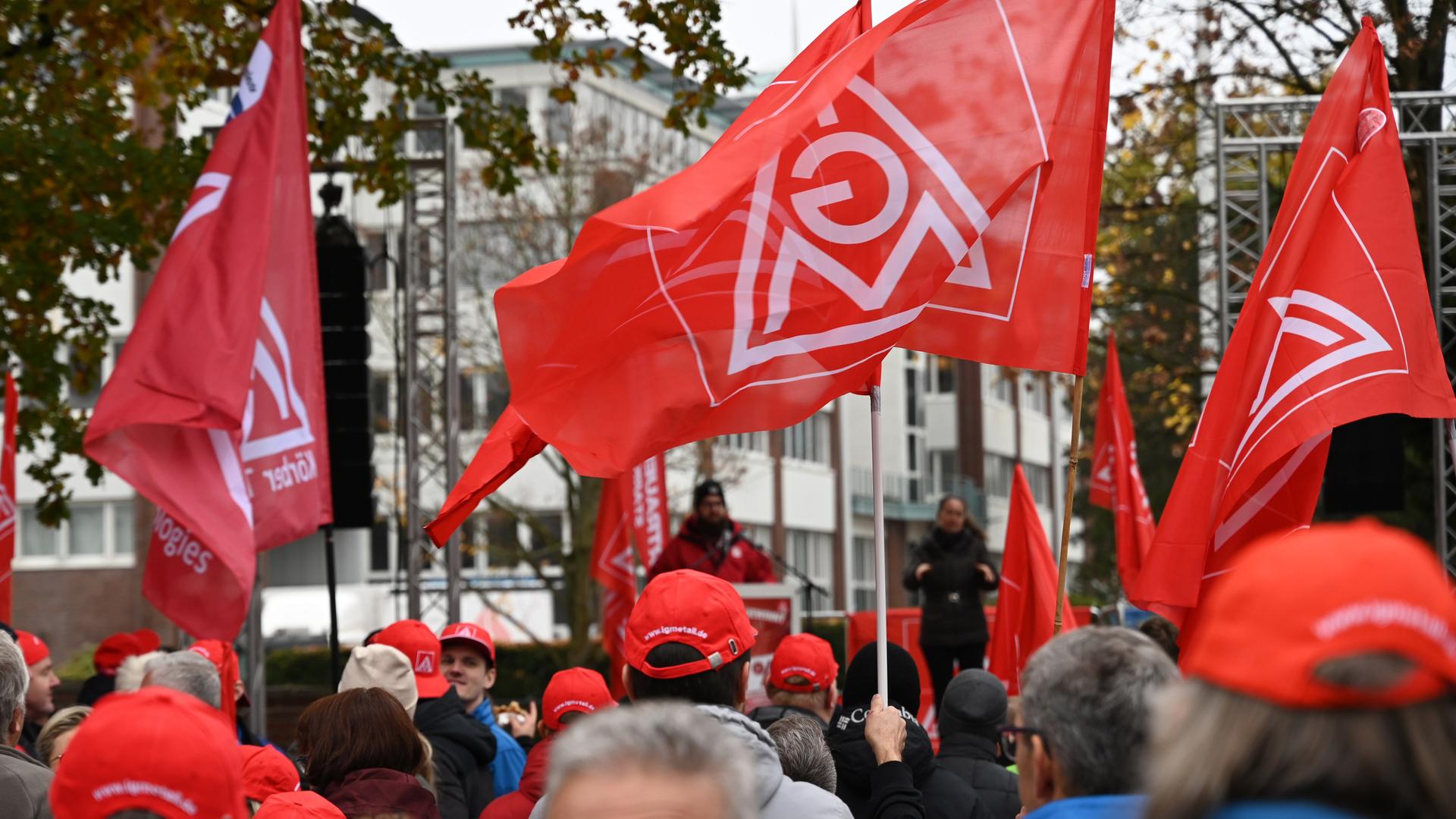 Hamburg: Teilnehmende stehen mit Fahnen mit dem Logo der IG Metall bei einer Kundgebung der IG Metall Küste vor dem Werk des Maschinenbauunternehmens Körber Technologies. 