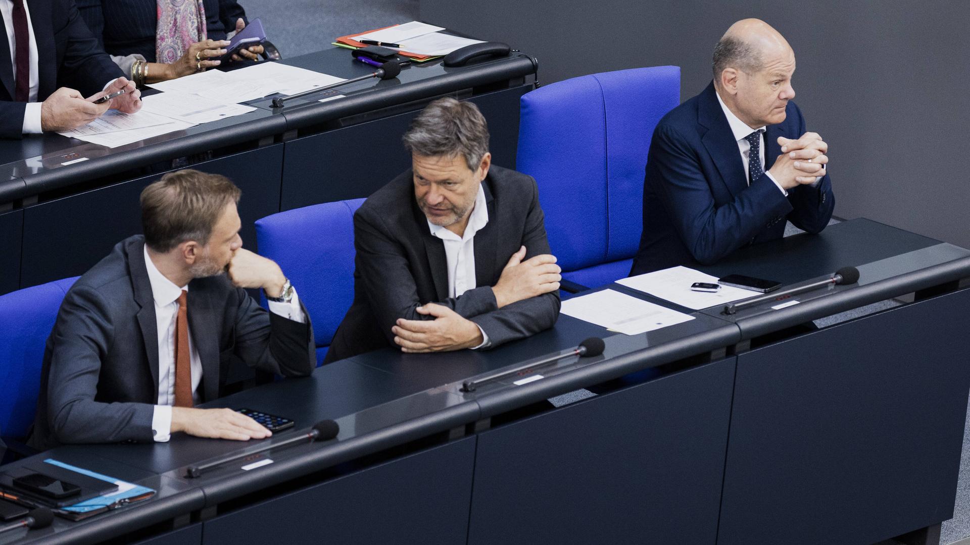 Von rechts nach links: Bundeskanzler Olaf Scholz, Wirtschaftsminister Robert Habeck und Finanzmnister Christian Lindner sitzen auf der Regierungsbank im Deutschen Bundestag Von rechts nach links: Bundeskanzler Olaf Scholz, Wirtschaftsminister Robert Habeck und Finanzmnister Christian Lindner sitzen auf der Regierungsbank im Deutschen Bundestag