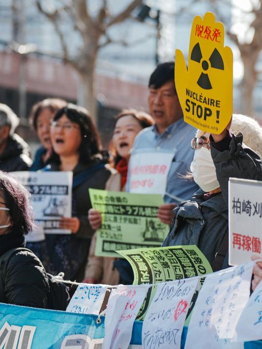 Eine Gruppe von Demonstrierenden, einige halten Banner unter anderem mit der Aufschrift "Stop Nuklear" in die Luft. Eine Gruppe von Demonstrierenden, einige halten Banner unter anderem mit der Aufschrift "Stop Nuklear" in die Luft.