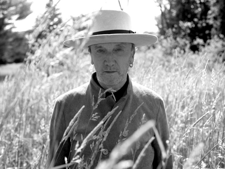 Marius Müller Westernhagen mit Hut steht in einem Kornfeld.