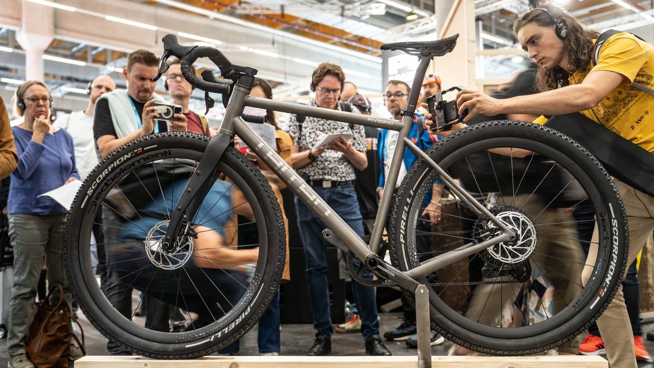 Ein Gravelbike des Herstellers Tritao ist auf einem Stand der Internationalen Fahrrad-Fachmesse Eurobike in den Frankfurter Messehallen ausgestellt. Dahinter stehen Besucher. 