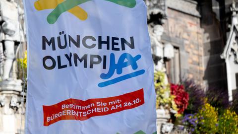 Eine Fahne mit der Aufschrift "München OlympiJA" weht auf dem Marienplatz vor dem Rathaus der bayerischen Landeshauptstadt. 