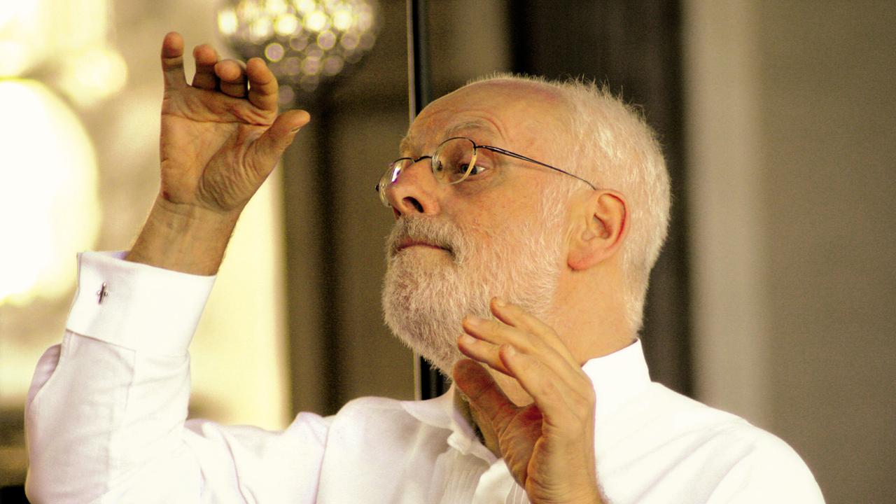 Ton Koopman dirigiert mit erhobenen Händen. Ton Koopman dirigiert mit erhobenen Händen.