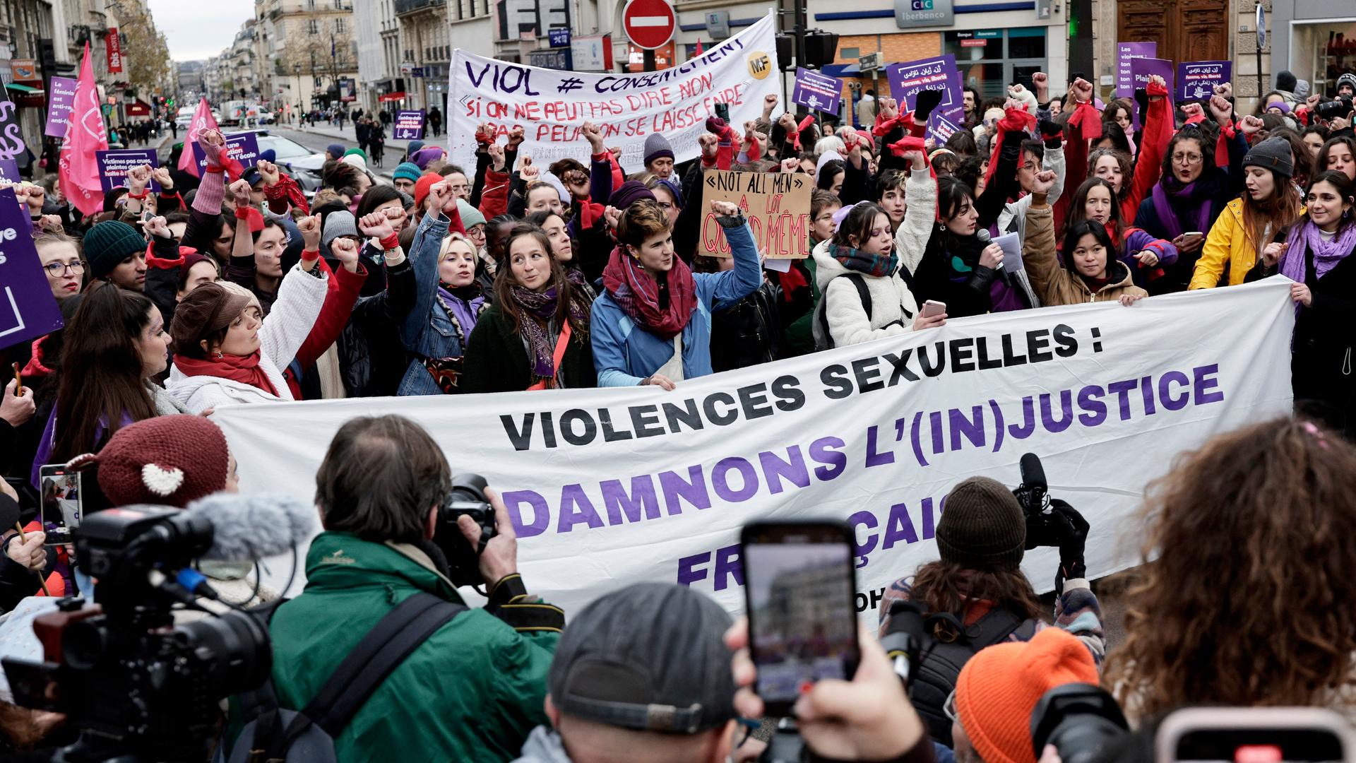 Demonstrantinnen und Demonstranten recken die Fäuste nach oben. Sie tragen große Spruchbänder und Papptafeln mit Forderungen über ihren Köpfen.