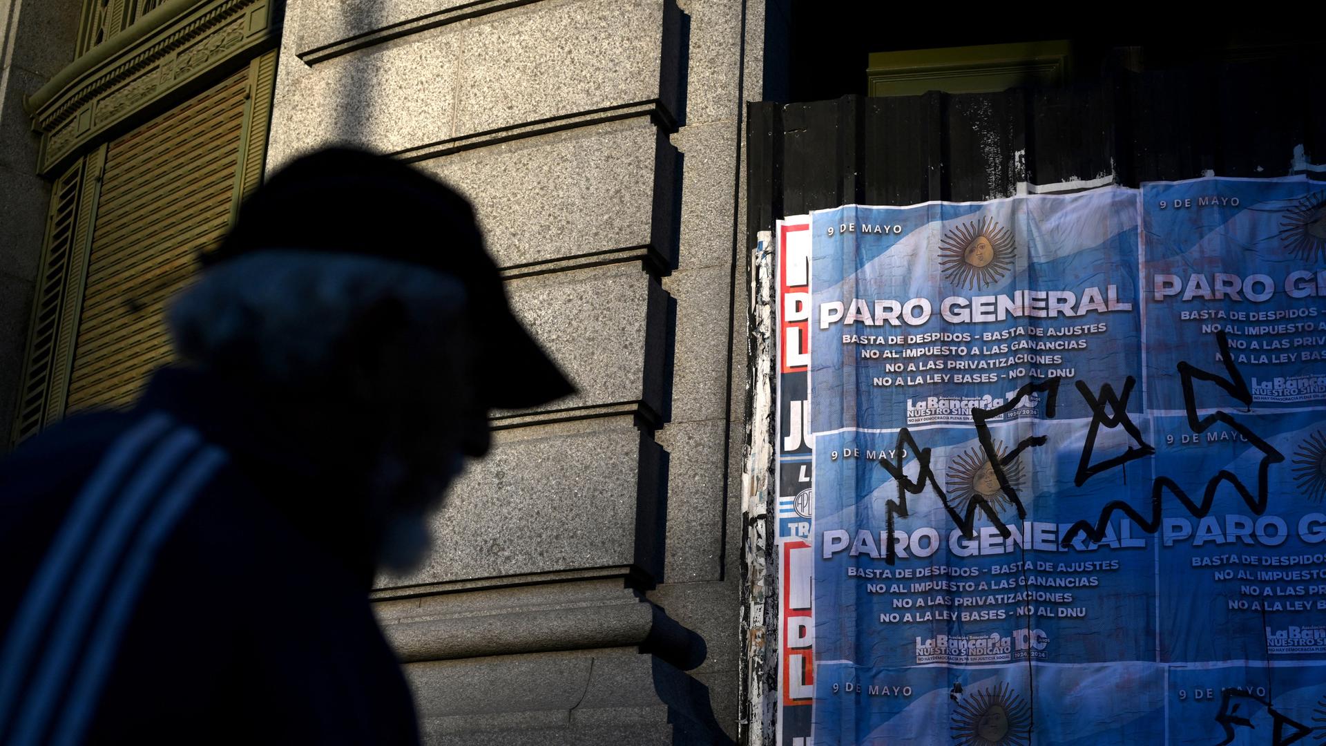 Ein Mann geht an einem Schild vorbei, das zum Generalstreik in Buenos Aires am 9. Mai 2024 aufruft.