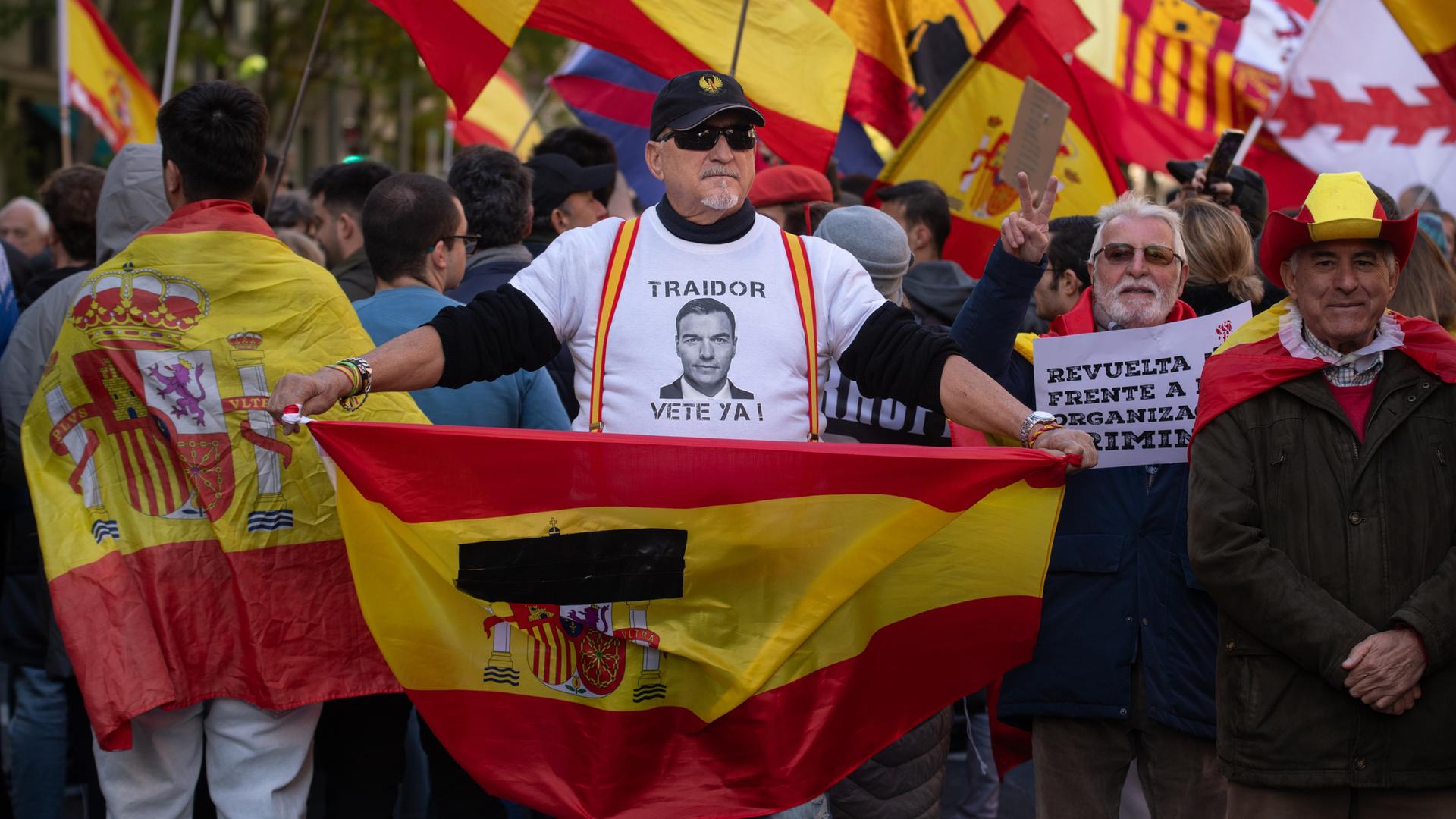 Ein Demonstrant in Madrid trägt ein T-Shirt mit der Aufschrift "Pedro Sánchez, Verräter, geh weg!"