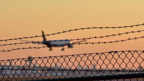 Symbolbild eines Abschiebeflugs. Zu sehen ist ein Flugzeug, das in einen Sonnenuntergang fliegt. 