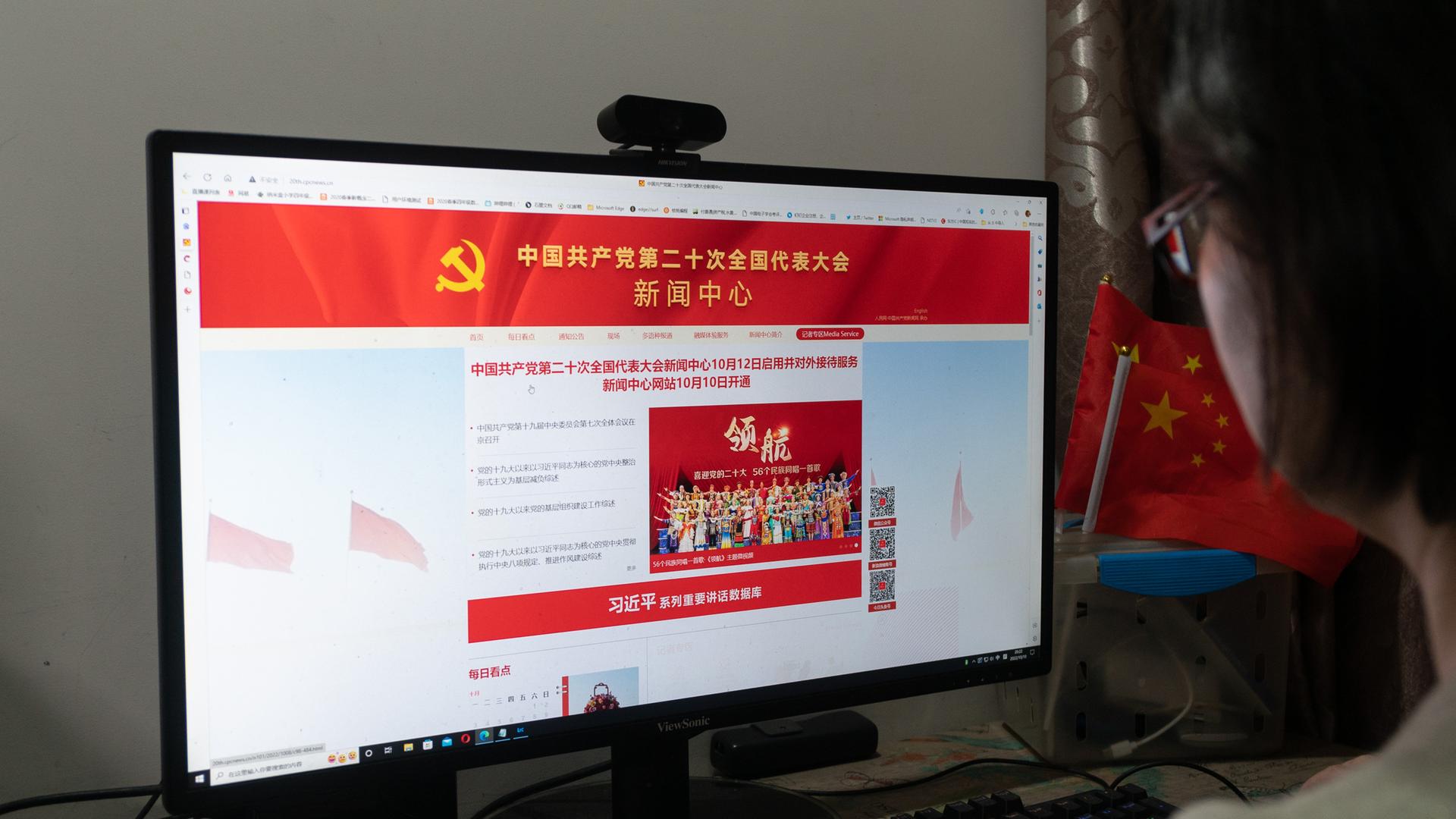 Eine Chinesin ruft an einem Rechner die Internetseite des  20. Parteitags der Kommunistischen Partei auf.