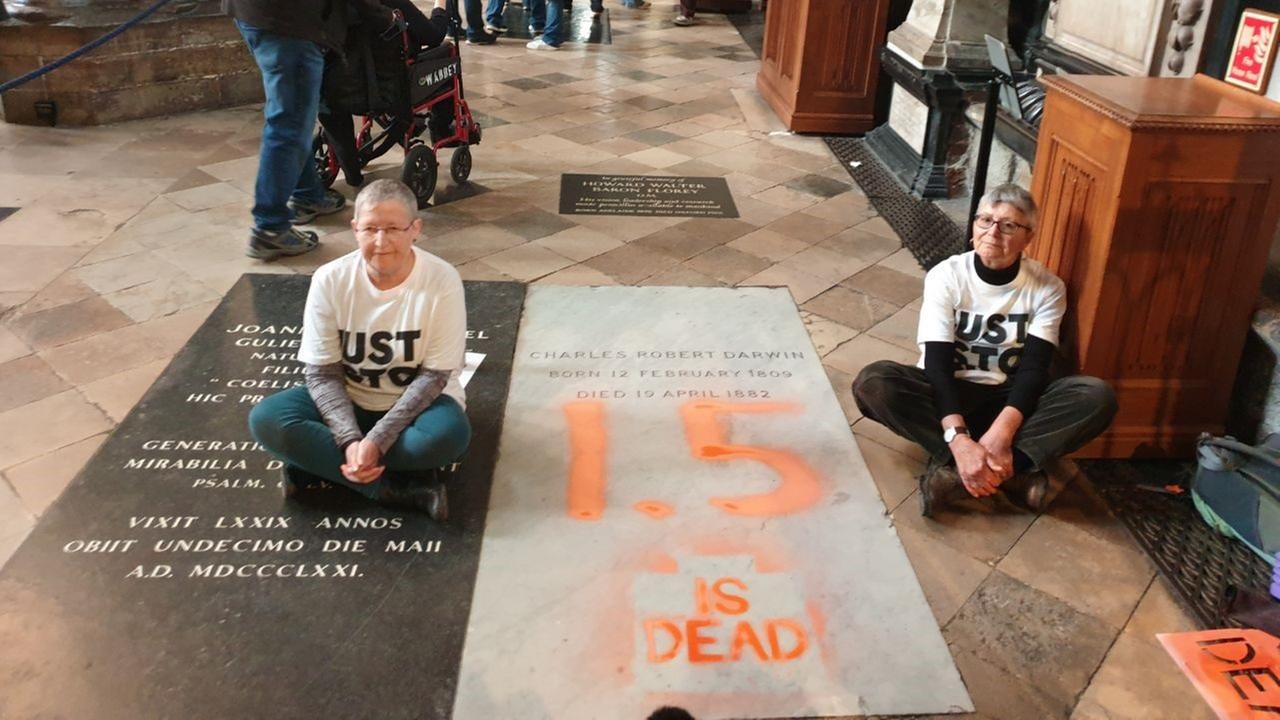 London: Ein Foto, herausgegeben von Just Stop Oil, zeigt die Demonstranten die neben dem Grab von Charles Darwin im nördlichen Seitenschiff der Westminster Abbey im Zentrum Londons sitzen, das sie mit der Aufschrift "1,5 is dead" besprüht haben.