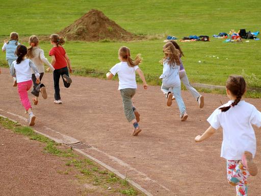 Kinder rennen auf einer Laufbah