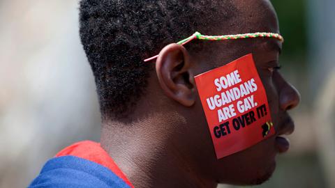 Ein Mann trägt auf seiner Wange einen Aufkleber, auf dem steht: „Some Ugandans are gay. Get over it.“