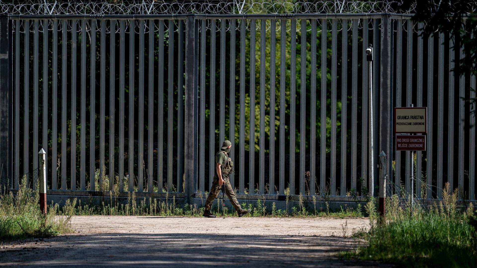 Ein Soldat läuft am Grenzzaun auf der polnischen Seite zu Belarus entlang.
