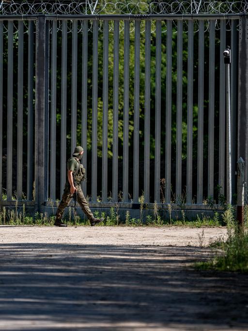 Ein Soldat läuft am Grenzzaun auf der polnischen Seite zu Belarus entlang. An der EU-Außengrenze zum Nachbarland Belarus hat Polen einen 5,5 Meter hohen Metallzaun mit Bewegungsmeldern und Nachtsichtkameras errichtet. 