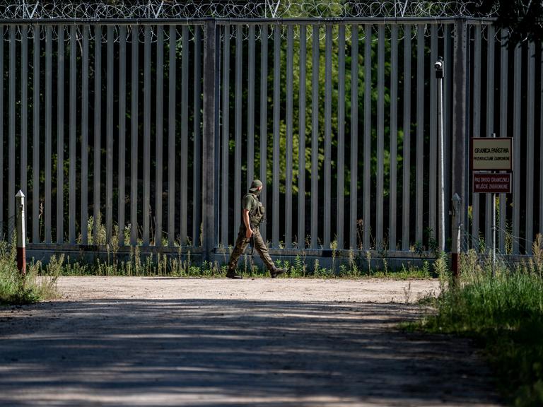 Ein Soldat läuft am Grenzzaun auf der polnischen Seite zu Belarus entlang. An der EU-Außengrenze zum Nachbarland Belarus hat Polen einen 5,5 Meter hohen Metallzaun mit Bewegungsmeldern und Nachtsichtkameras errichtet. 