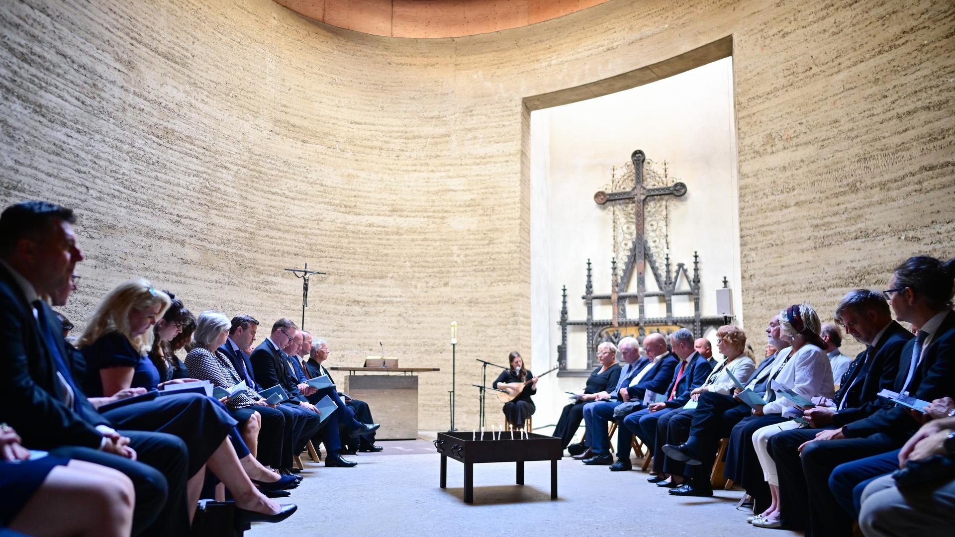 Teilnehmer sitzen während einer Gedenkandacht zum 64. Jahrestag des Mauerbaus in der Kapelle der Versöhnung.