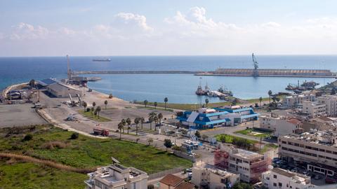 Eine Stadt mit einem Hafen, dahinter das Meer.