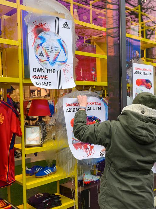 Aktivisten von Extinction Rebellion bekleben das Adidas-Geschäft in Berlin mit Plakaten mit modifizierter Adidas-Werbung.