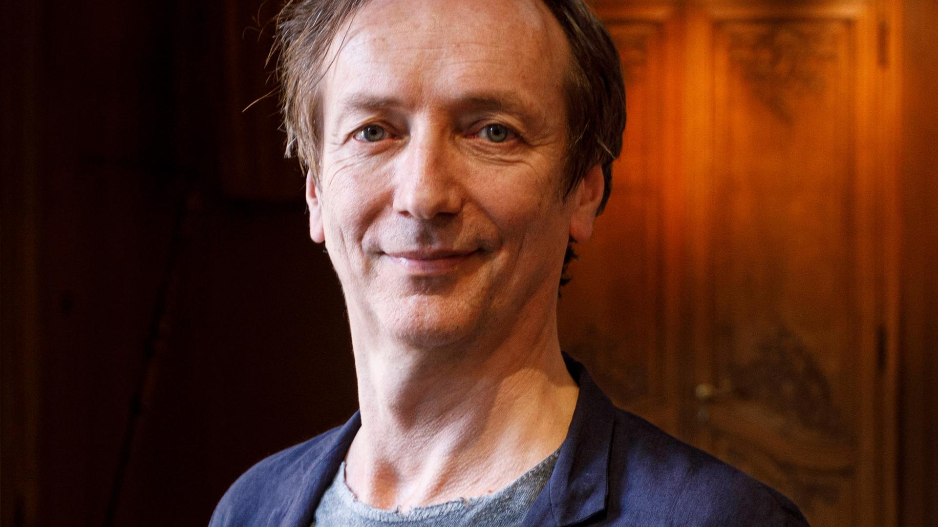 Hauschka lächelt in die Kamera. Er trägt ein dunkelblaues Sakko über grauem Shirt. Hauschka lächelt in die Kamera. Er trägt ein dunkelblaues Sakko über grauem Shirt.