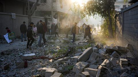 Palästinenser inspizieren eine zerstörte Straße und Häuser im Gazastreifen.