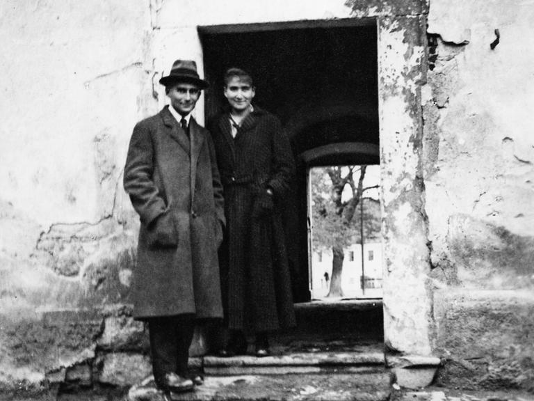 Historisches Schwarzweißfoto von Franz Kafka und seiner Schwester Ottla, die nebeneinander in einem Türrahmen stehen.
