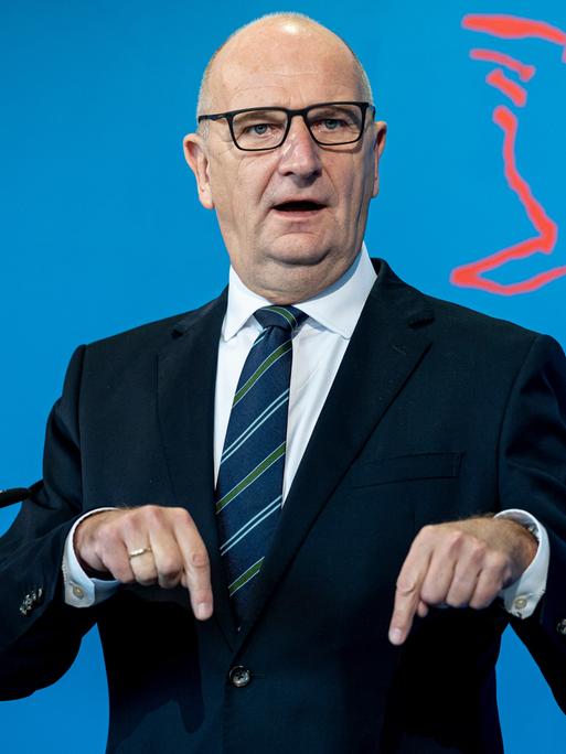 Dietmar Woidke (SPD), der Ministerpräsident von Brandenburg, spricht auf einer Pressekonferenz.  Hinter ihm ist eine blaue Rückwand mit Teilen des Schriftzugs "Brandenburg" und einem Vogelsymbol.