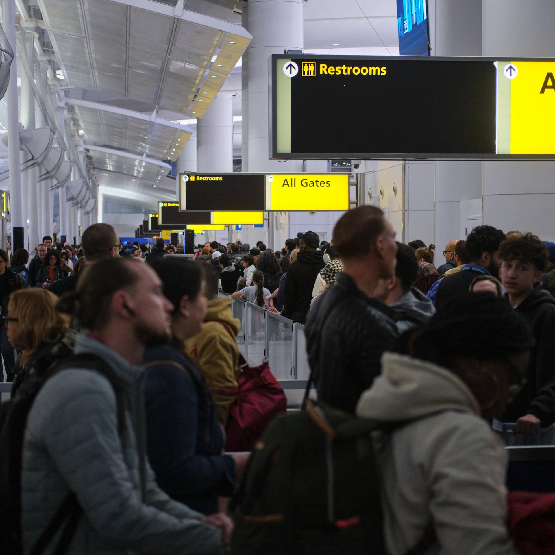 Viele Menschen stehen an der Sicherheitskontrolle im Flughafen JFK in New York.
