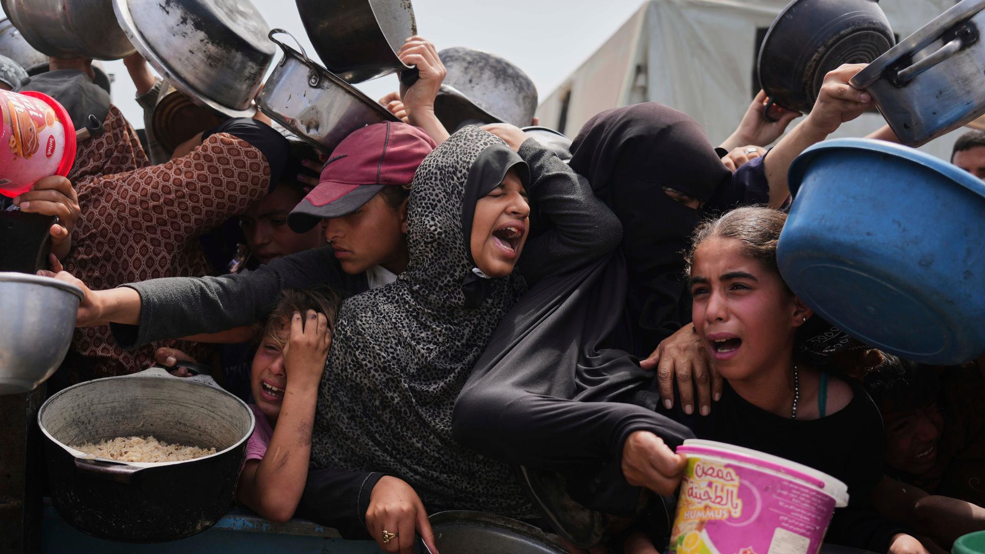Palästinenser stehen an einem Verteilungszentrum für Lebensmittel im Gazastreifen an. Es herrscht Gedränge; die Verzweiflung der Menschen ist groß. (Archivbild)