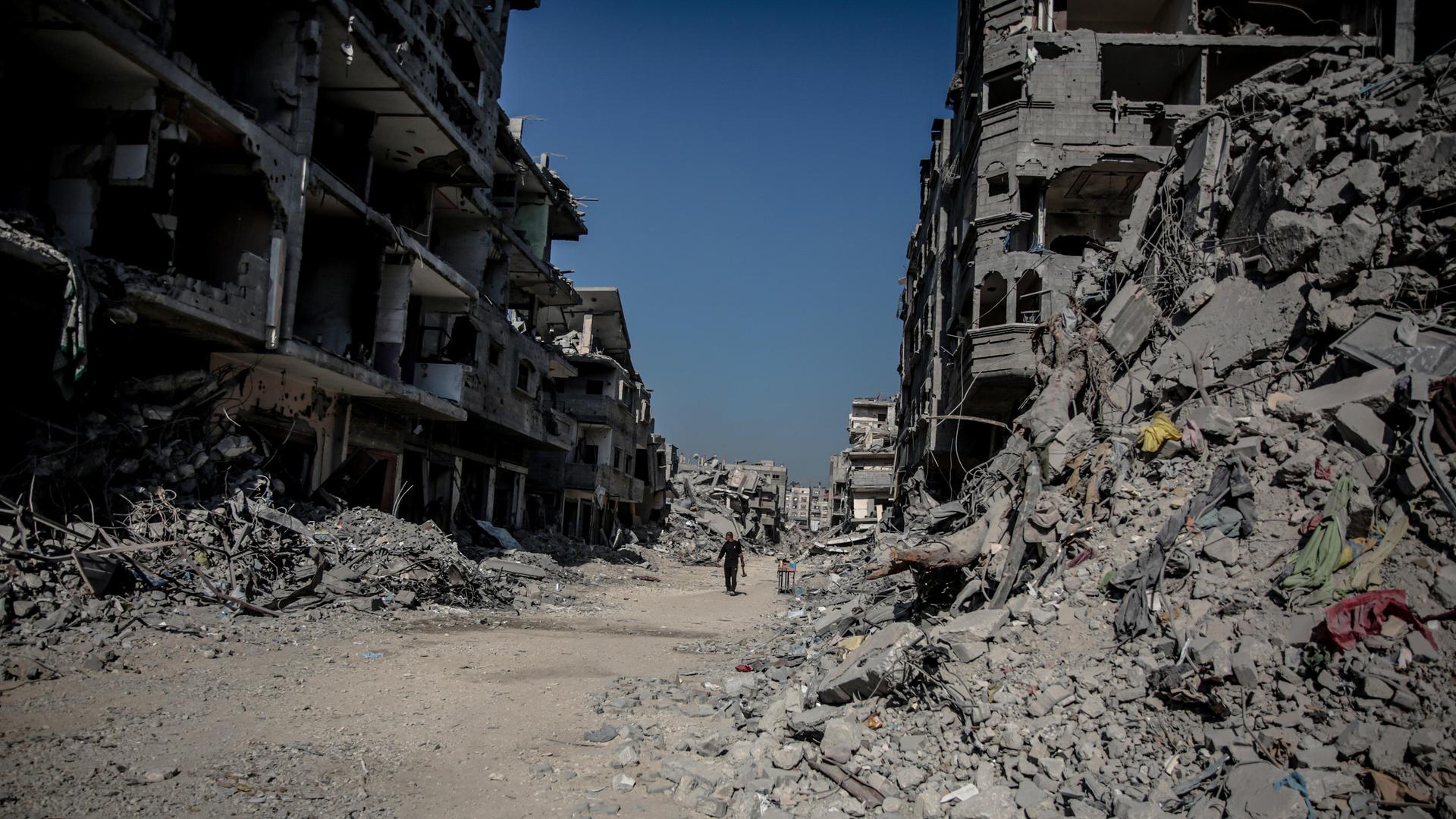 Das Foto zeigt ein Schneise inmitten von Ruinen durch die ein Mensch läuft in der durch den Krieg zerstörten Stadt Jabalia im Gazastreifen am 25. Oktober 2025. Das Foto zeigt ein Schneise inmitten von Ruinen durch die ein Mensch läuft in der durch den Krieg zerstörten Stadt Jabalia im Gazastreifen am 25. Oktober 2025.