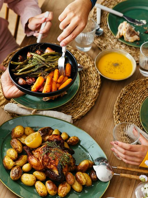 Freunde sitzen gemeinsam an einem Tisch und essen gemeinsam. 