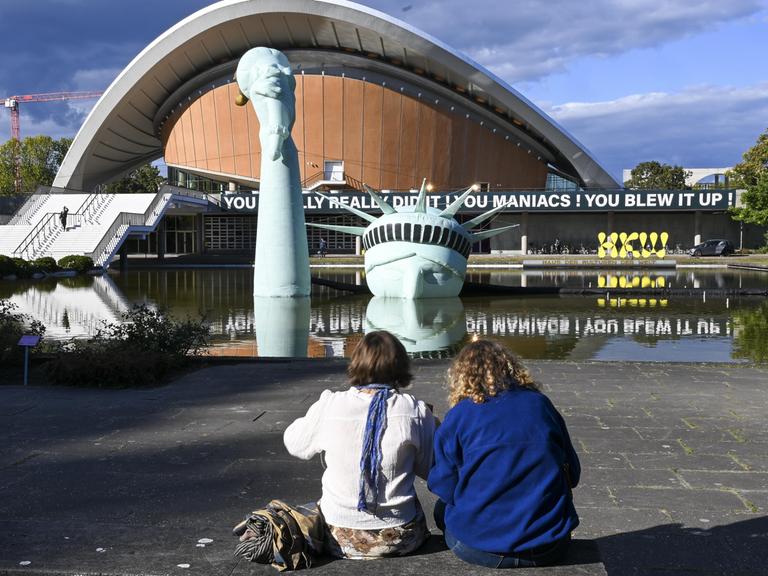 Im Rahmen der Ausstellung „Possibility of Unvernunft” in Berlin schauen zwei Besucherinnen auf eine aufblasbare Nachbildung der Freiheitsstatue, die im Brunnen vor dem Haus der Kulturen der Welt versunken ist. Im Rahmen der Ausstellung „Possibility of Unvernunft” in Berlin schauen zwei Besucherinnen auf eine aufblasbare Nachbildung der Freiheitsstatue, die im Brunnen vor dem Haus der Kulturen der Welt versunken ist.