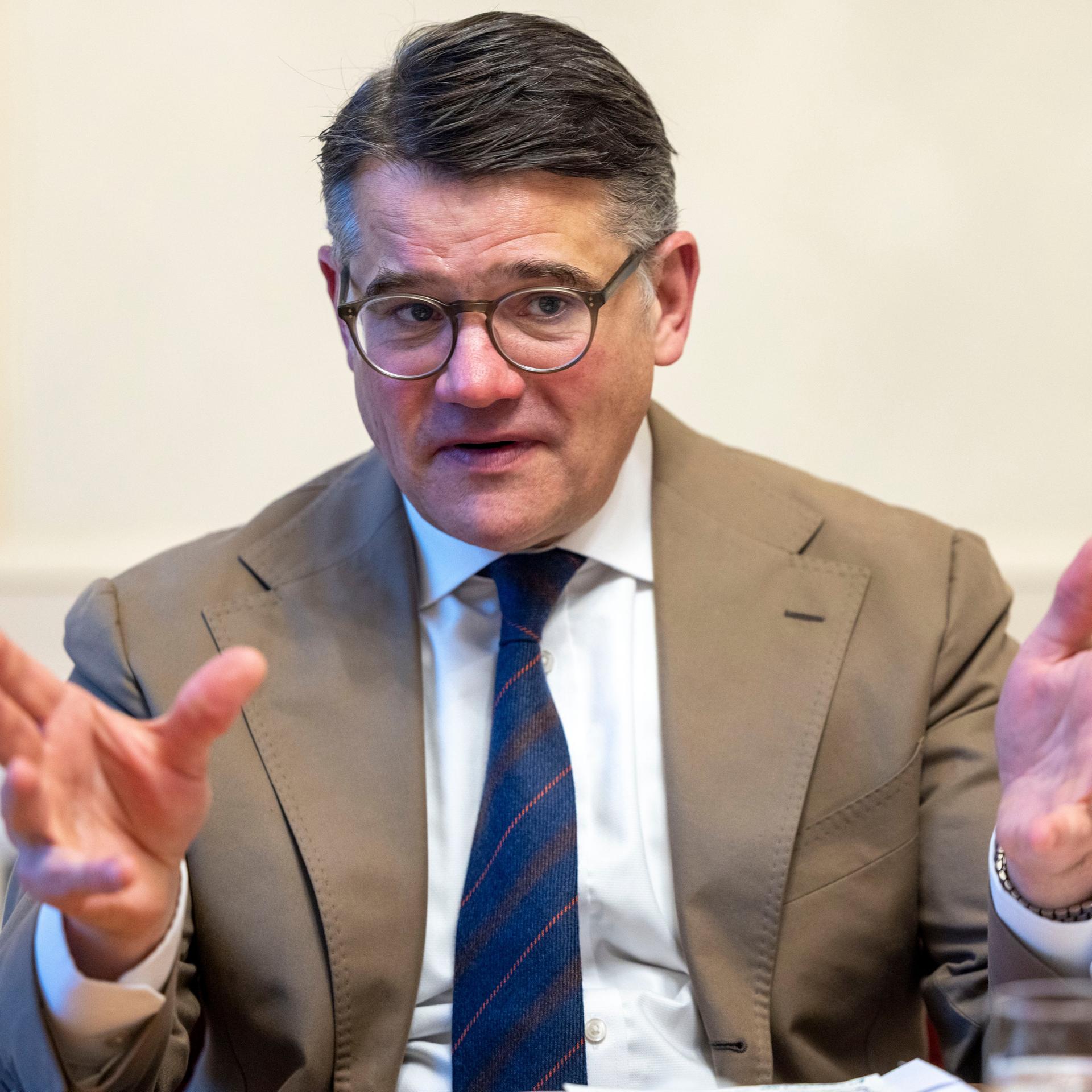 Der hessische Ministerpräsident Boris Rhein (CDU) beim Interview. Er trägt einen hellen Anzug und gestikuliert mit den Händen.  