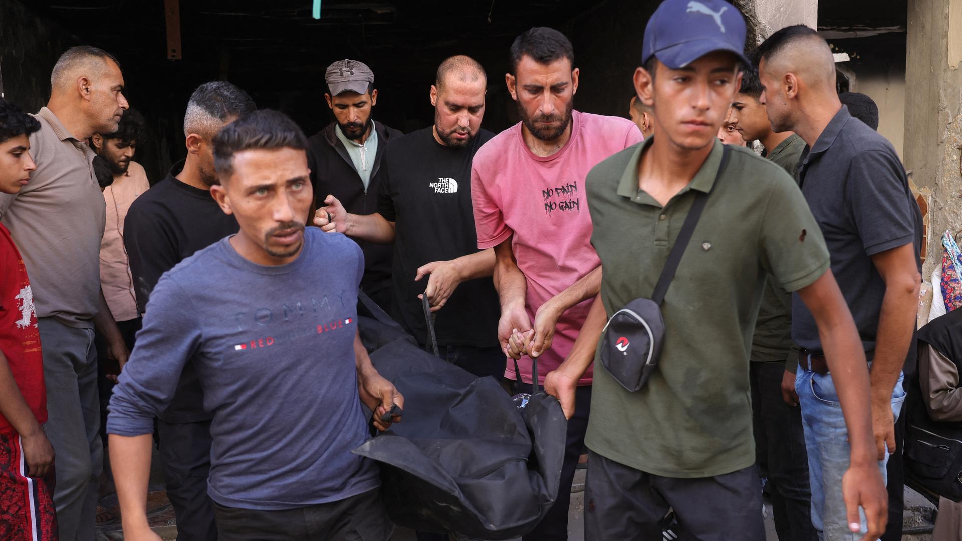 Das Foto zeigt Männer in Gaza-Stadt, die einen Leichnam in einem Sack tragen. Das Foto zeigt Männer in Gaza-Stadt, die einen Leichnam in einem Sack tragen.