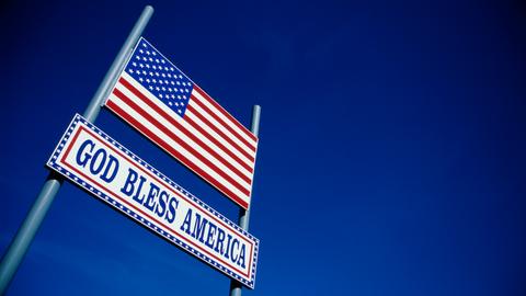 Eine US-amerikanische Flagge und der Spruch "God Bless America" vor 