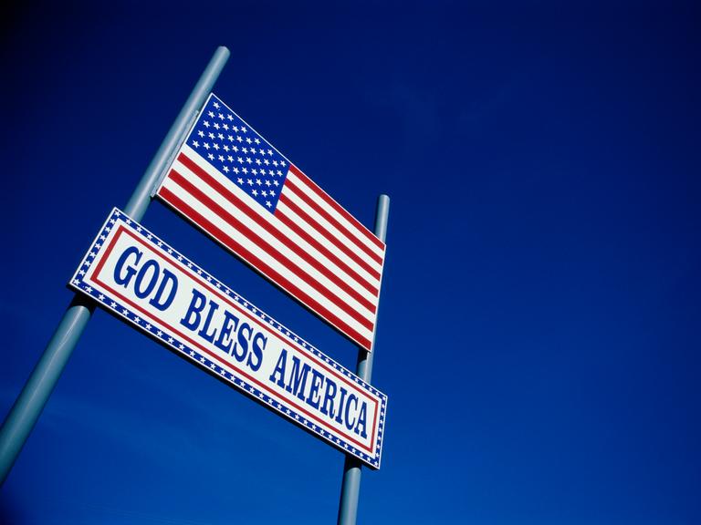 Eine US-amerikanische Flagge und der Spruch "God Bless America" vor 