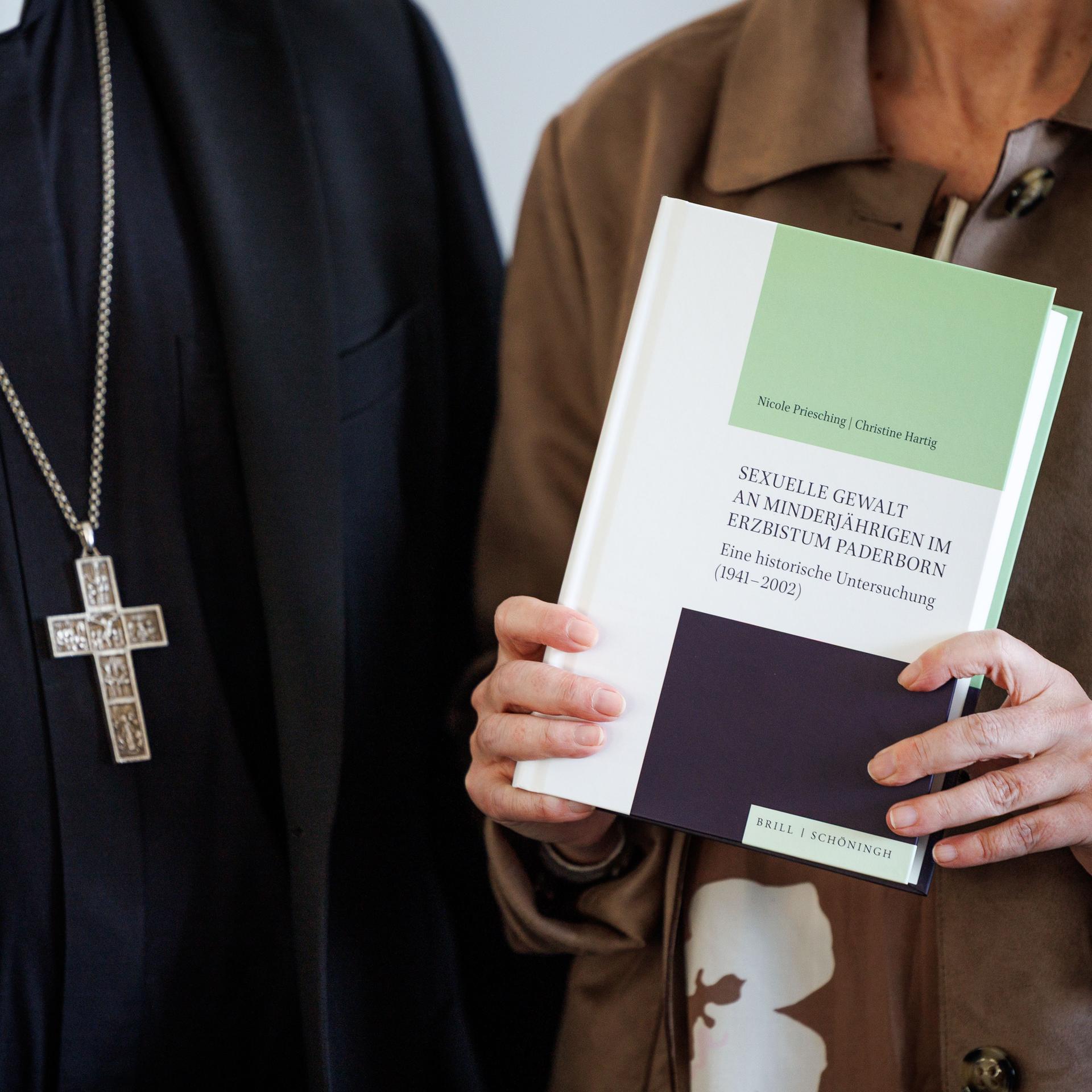 Udo Markus Bentz, Erzbischof von Paderborn, und Nicole Priesching, Kirchenhistorikerin und Wissenschaftlerin, stehen zusammen bei einer Pressekonferenz in der Universität Paderborn zur Vorstellung der Ergebnisse einer Missbrauchs-Studie.