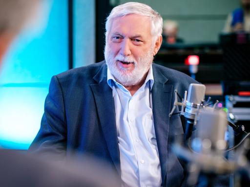 Der frühere EU-Kommissar Franz Fischler (ÖVP) sitzt in einem blauen Anzug in einer Podcastaufzeichnung. 