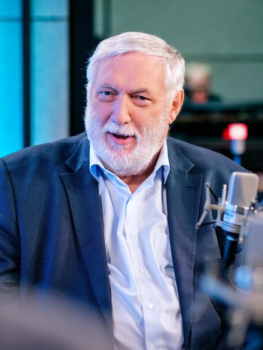 Der frühere EU-Kommissar Franz Fischler (ÖVP) sitzt in einem blauen Anzug in einer Podcastaufzeichnung. 