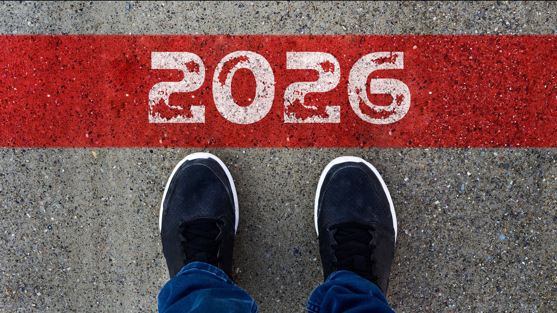 Eine Person steht vor der Markierung 2026 und blickt auf einen Weg. Das Bild steht für einen Neuanfang