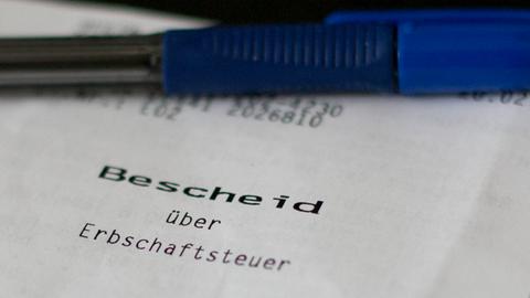 Ein Bescheid über die Erbschaftssteuer liegt auf einem Schreibtisch. 
