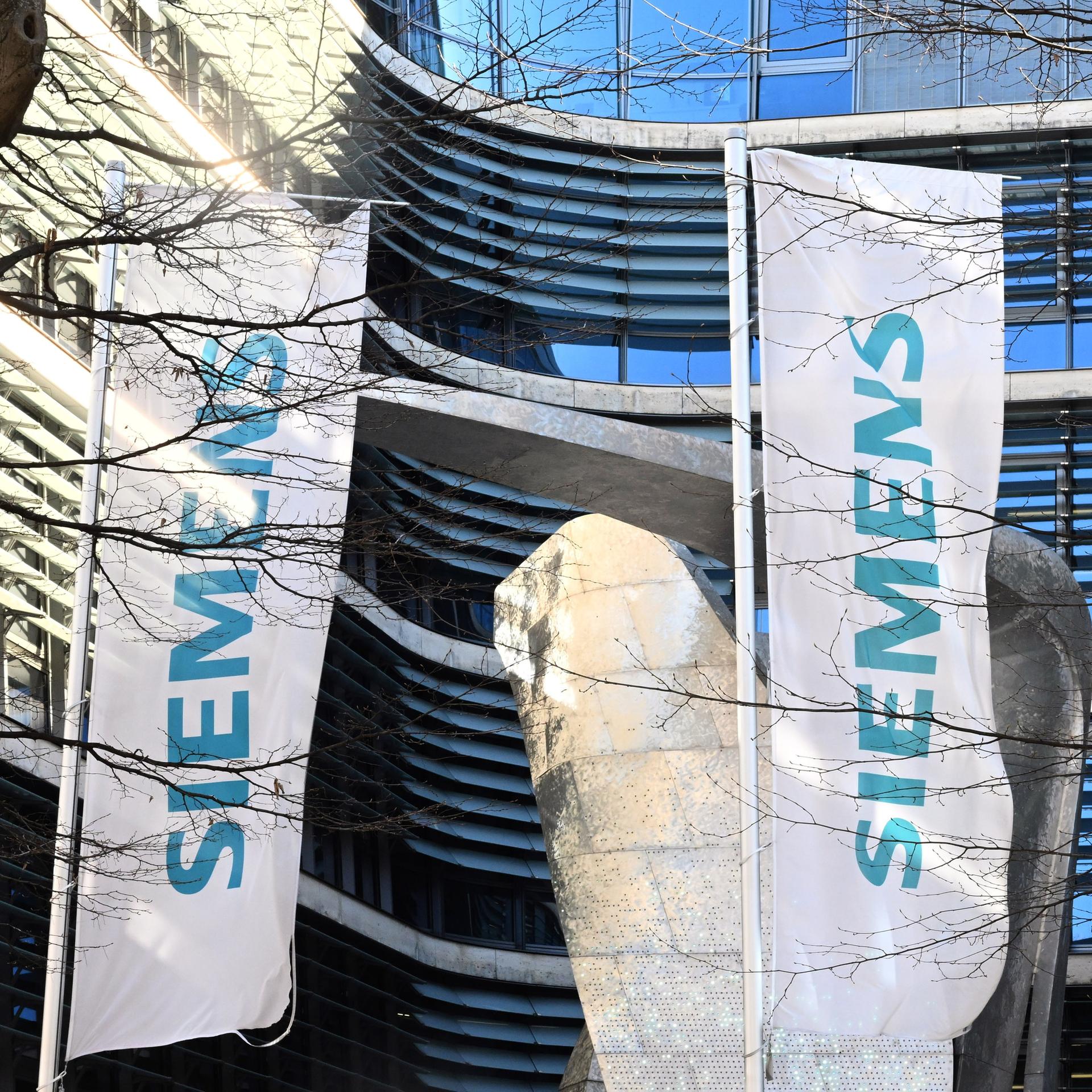 Der Schriftzug "Siemens" ist auf Fahnen vor der Firmenzentrale des Mischkonzerns in München. 