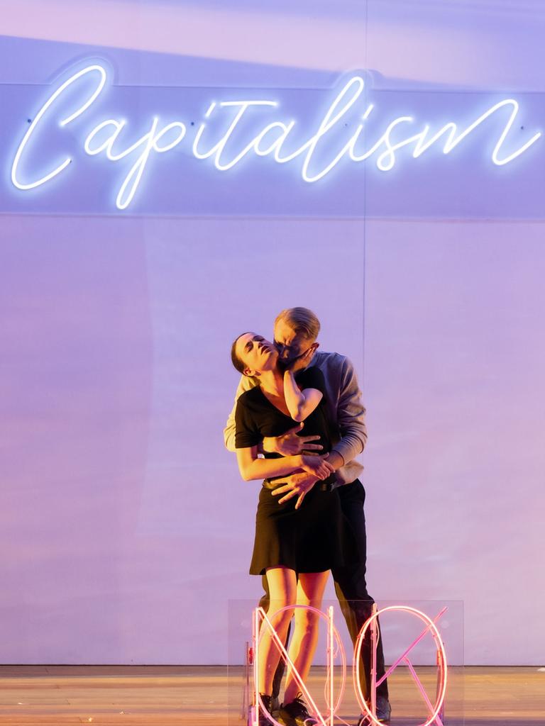 Im Bild der Inszenierung von "Le Nozze di Figaro" umarmt sich ein Liebespaar unter dem Neonschriftzug "Capitalism".