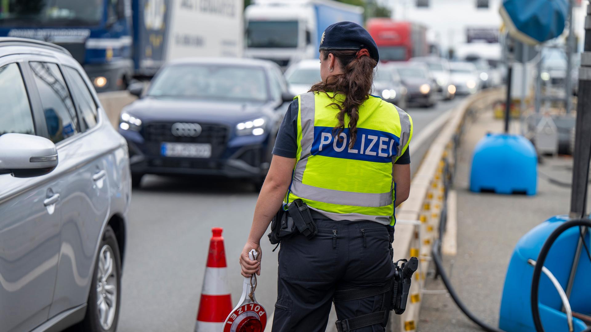 Eine Polizistin steht bei Grenzkontrollen der Bundespolizei am Grenzübergang zwischen Österreich und Deutschland an der Autobahn A8 nahe Salzburg (Österreich)