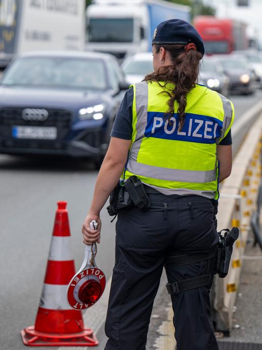 Eine Polizistin steht bei Grenzkontrollen der Bundespolizei am Grenzübergang zwischen Österreich und Deutschland an der Autobahn A8 nahe Salzburg (Österreich)