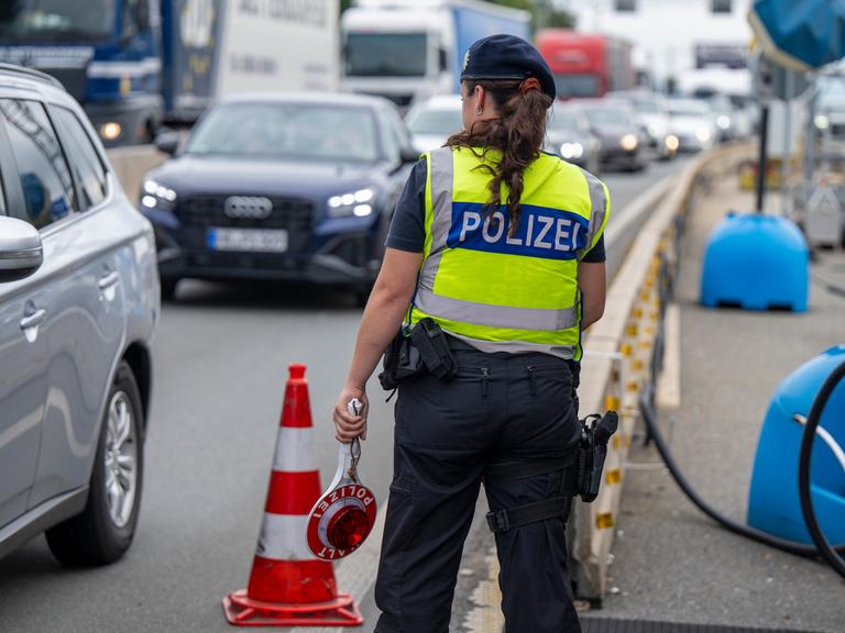 Eine Polizistin steht bei Grenzkontrollen der Bundespolizei am Grenzübergang zwischen Österreich und Deutschland an der Autobahn A8 nahe Salzburg (Österreich)